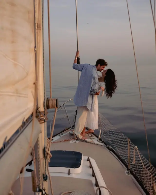 Paar an Deck einer Yacht mit Blick auf eine ruhige Bucht
