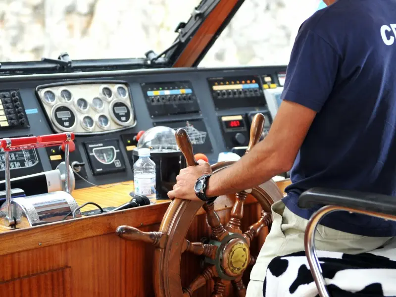 Kapitän und Gäste besprechen eine Seekarte auf einer Yacht